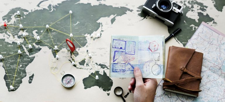aerial-view-hand-holding-passport-planning-journey-with-map